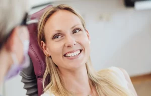 Female patient with healthy smile on dental chair